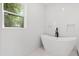 Spa-like bathroom featuring a freestanding tub, tiled walls, and a garden view from the window at 3399 Freeman Hill Rd, Johns Island, SC 29455