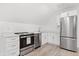 Bright kitchen featuring stainless steel appliances, white cabinetry, and light wood-look flooring at 3399 Freeman Hill Rd, Johns Island, SC 29455