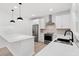 Well-lit kitchen features stainless steel appliances, stylish white cabinets, quartz countertops and a kitchen island at 3399 Freeman Hill Rd, Johns Island, SC 29455