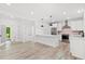 Bright, open kitchen features stainless steel appliances, modern white cabinets, and a large island with pendant lighting at 3399 Freeman Hill Rd, Johns Island, SC 29455