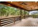 Spacious covered porch with wood ceiling, fan, dark railings, and stunning backyard views at 3399 Freeman Hill Rd, Johns Island, SC 29455