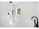 Modern shower featuring white tiles, rainfall showerhead, and black fixtures, complimented by a garden view at 3399 Freeman Hill Rd, Johns Island, SC 29455