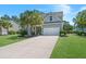 Charming two-story home with a well-manicured lawn, palm trees, and a long concrete driveway at 4019 Cascades Thrust, Summerville, SC 29483