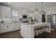 Well-lit kitchen featuring white cabinets, marble backsplash, and stainless appliances centered around an island with barstool seating at 4019 Cascades Thrust, Summerville, SC 29483