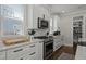 Close-up of a kitchen featuring a stainless steel oven, marble countertops, white cabinets, and a tile backsplash at 4019 Cascades Thrust, Summerville, SC 29483
