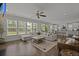 Inviting living room with large windows, hardwood floors, ceiling fan, and open access to the kitchen at 4019 Cascades Thrust, Summerville, SC 29483