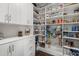 Organized pantry with white shelves and drawers, filled with a variety of food items and storage containers at 4019 Cascades Thrust, Summerville, SC 29483