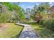 Picturesque backyard with a wooden walkway leading to the water, surrounded by trees at 402 Bay Creek Dr, Charleston, SC 29414