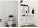Bathroom with white cabinetry, modern fixtures, two mirrors and a standard toilet at 402 Bay Creek Dr, Charleston, SC 29414