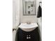A cozy powder room featuring a vanity with a black cabinet and silver framed mirror at 402 Bay Creek Dr, Charleston, SC 29414