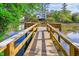 Wooden dock on the water surrounded by trees and greenery, leading to a home in the distance at 402 Bay Creek Dr, Charleston, SC 29414