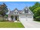 Charming two-story home featuring a well-manicured lawn, attached two car garage, and welcoming front porch at 402 Bay Creek Dr, Charleston, SC 29414