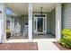 Inviting front porch with rocking chairs, columns, and decorative details at the home's entrance at 402 Bay Creek Dr, Charleston, SC 29414