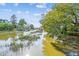 Scenic marsh view with houses and a wooden structure in the distance, surrounded by lush trees at 402 Bay Creek Dr, Charleston, SC 29414