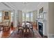Bright dining room with a chandelier, fireplace, bay windows and a traditional-style table set on a large rug at 41 Legare St # C, Charleston, SC 29401