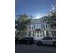 Traditional two-story facade with bay windows and grey shutters in an urban setting, surrounded by parked cars and trees at 41 Legare St # C, Charleston, SC 29401