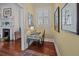 Hallway nook with yellow walls, window, shutters, wood floors, and artwork creates a cozy, inviting space at 41 Legare St # C, Charleston, SC 29401