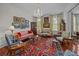 Elegant living room with detailed moldings, chandelier, artwork, and seating with an antique rug at 41 Legare St # C, Charleston, SC 29401