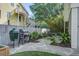 Charming backyard patio area features pavers, a grill, and outdoor seating amidst lush greenery at 413 Station 22 1/2 St, Sullivans Island, SC 29482