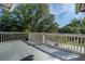Inviting balcony with a potted plant overlooks a serene neighborhood street and lush greenery at 413 Station 22 1/2 St, Sullivans Island, SC 29482