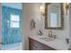 Bathroom featuring a wood vanity, stone countertops, and a blue-tiled shower at 413 Station 22 1/2 St, Sullivans Island, SC 29482