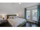 Bedroom featuring white bedding, hardwood floors, and patio doors at 413 Station 22 1/2 St, Sullivans Island, SC 29482