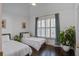 Light filled bedroom featuring two twin beds, plantation shutters, and hardwood floors at 413 Station 22 1/2 St, Sullivans Island, SC 29482
