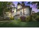 Beautiful coastal home with lush landscaping and a welcoming porch at dusk at 413 Station 22 1/2 St, Sullivans Island, SC 29482