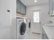 Bright laundry room with gray tile flooring, blue cabinets, and a modern washer and dryer at 413 Station 22 1/2 St, Sullivans Island, SC 29482