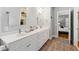Bright bathroom with double vanity, wood-look tile, and an open doorway into the bedroom at 4524 Orr St, North Charleston, SC 29405