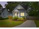 Charming blue two-story home with a welcoming front porch and well-maintained landscaping at twilight at 4524 Orr St, North Charleston, SC 29405