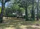 Large backyard featuring a well-maintained lawn, mature trees, and a light-colored privacy fence at 638 Leisure Ln, Mount Pleasant, SC 29464