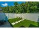 Private backyard oasis with artificial turf, stone pavers, and a white vinyl fence at 754 Certificate Ct, Charleston, SC 29414
