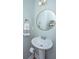Stylish powder room featuring a pedestal sink, round mirror, and decorative wall accents at 754 Certificate Ct, Charleston, SC 29414