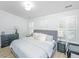 Bright primary bedroom with wood-look floors, gray bed frame, neutral bedding, plantation shutters, and black dresser at 78 Branch Creek Trl, Summerville, SC 29483