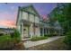 Charming two-story house featuring a welcoming front porch with an American flag at sunset at 78 Branch Creek Trl, Summerville, SC 29483