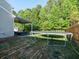 Large backyard with a trampoline, patio area, lush greenery and fencing at 8035 Mckayla Rd, Summerville, SC 29483