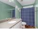 Well-lit bathroom featuring a modern vanity, mirror, and a shower with a blue curtain at 8035 Mckayla Rd, Summerville, SC 29483