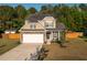 Two-story home with a manicured lawn, attractive landscaping, and attached garage provides great curb appeal at 8035 Mckayla Rd, Summerville, SC 29483