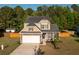 Charming two-story home with stone accents, well-kept lawn, and an attached two car garage at 8035 Mckayla Rd, Summerville, SC 29483
