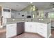 Bright kitchen with stainless steel dishwasher, sink, white cabinets, and a high ceiling extending to the living area at 8035 Mckayla Rd, Summerville, SC 29483