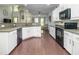Kitchen with white cabinets, gray countertops, stainless steel appliances, hardwood floor, and an open view to the living space at 8035 Mckayla Rd, Summerville, SC 29483