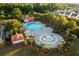 Aerial view showcases a community pool with splash pad, lounge chairs, and landscaped surroundings at 8035 Mckayla Rd, Summerville, SC 29483