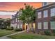 Brick townhome featuring a well-manicured lawn and inviting front entrance at sunset at 822 Rue Dr, Charleston, SC 29414