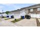 A two car garage with a white exterior and driveway, with additional parking and golf cart at 822 Rue Dr, Charleston, SC 29414
