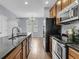 Well-lit kitchen featuring dark granite countertops, stainless appliances, and wood cabinets at 822 Rue Dr, Charleston, SC 29414