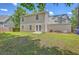 Spacious backyard view showcasing lush green grass, a home with tan siding, and double doors to the outside at 8632 Madelyn St, North Charleston, SC 29406