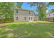 Large grassy backyard with a wooden privacy fence and a two-story house featuring a well-maintained lawn at 8632 Madelyn St, North Charleston, SC 29406