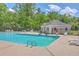 Large community pool, complete with lounge chairs, fenced in area, and lush surrounding landscape at 8632 Madelyn St, North Charleston, SC 29406
