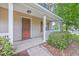 View of the front door and porch of a tan two story home with nice landscaping at 8632 Madelyn St, North Charleston, SC 29406
